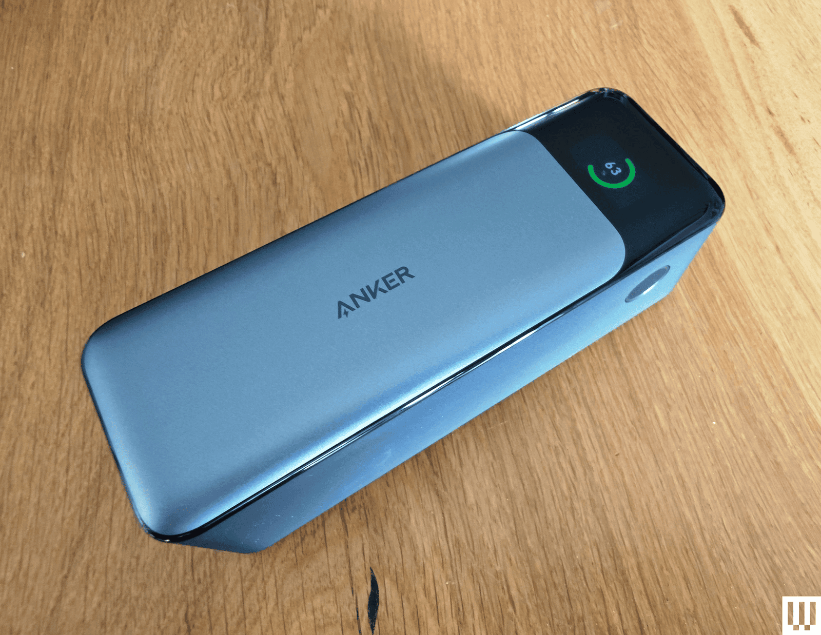 Silver rectangular portable charger with a narrow screen on the end