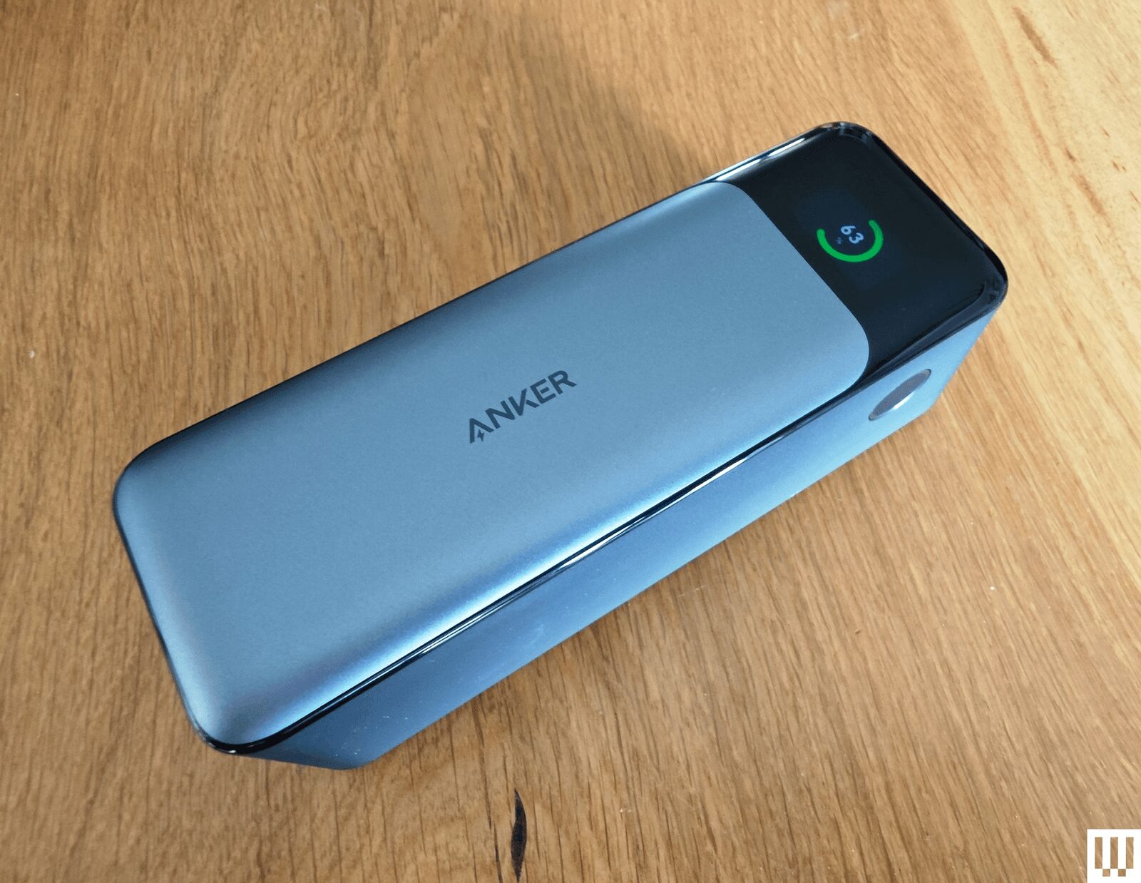 Silver rectangular portable charger with a narrow screen on the end