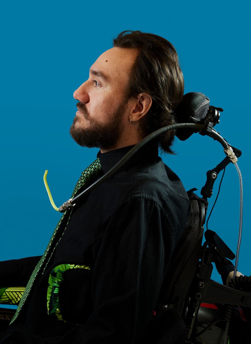 A man, seen in profile, sits in a wheelchair.