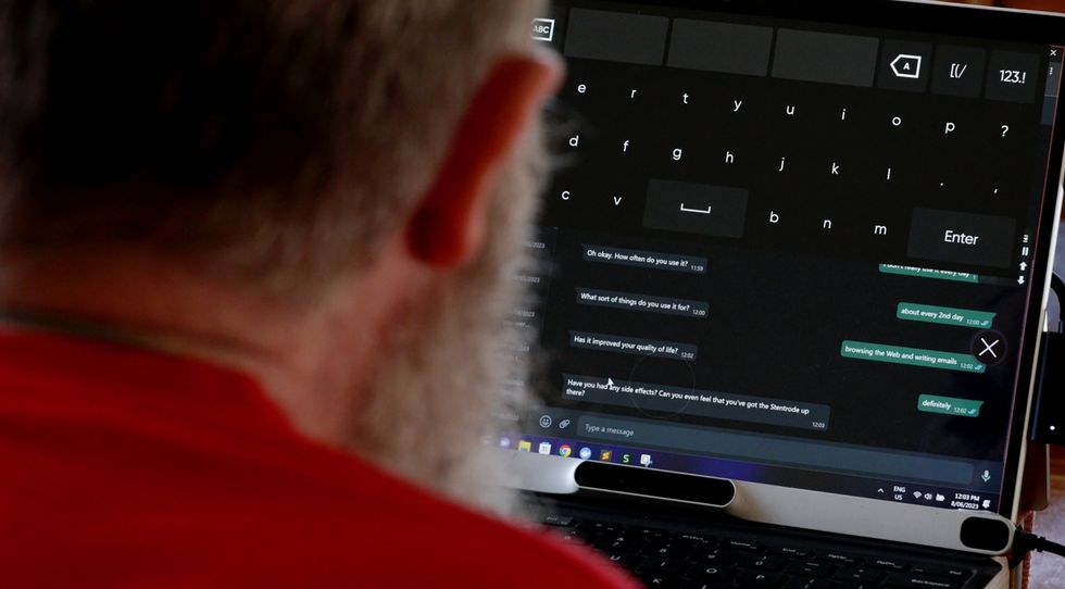 Man using a large on-screen keyboard to type messages on a tablet computer