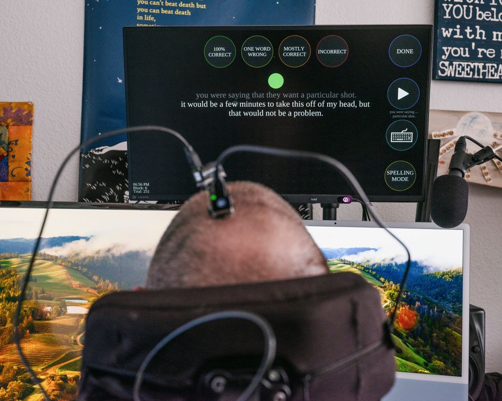 Person using a brain-computer interface to control text on a monitor.