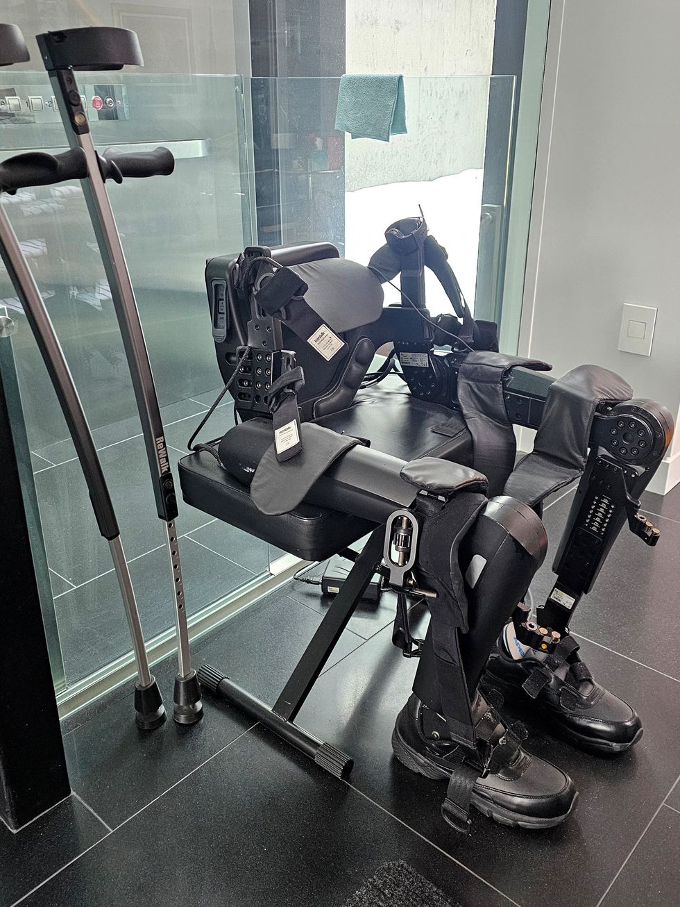 Powered exoskeleton suit and crutches positioned in a modern clinical room