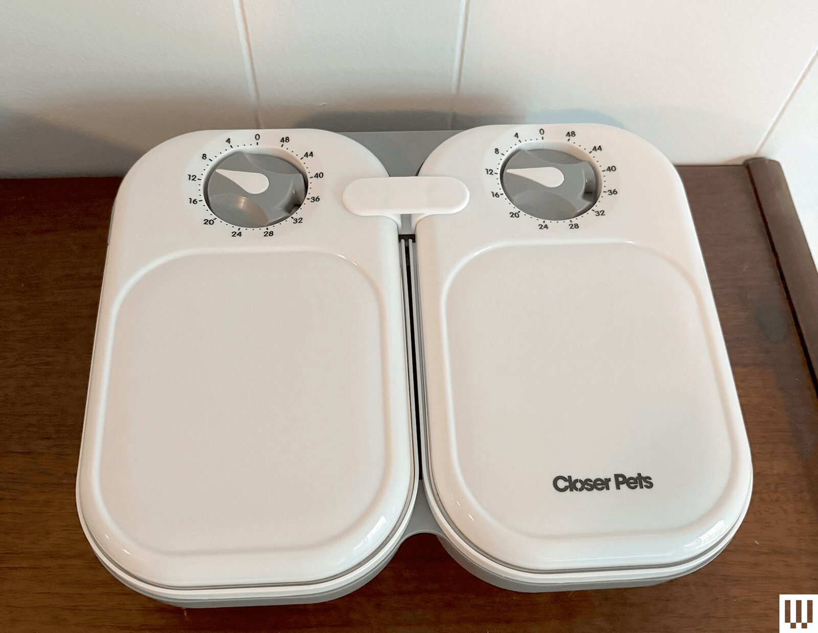 Front view of the Closer Pets C200 Automatic Pet Feeder two white ovalshaped containers with a timer dial at the top of...