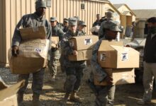 Aid workers carrying boxes of humanitarian supplies at Bagram in Afghanistan
