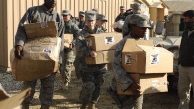 Aid workers carrying boxes of humanitarian supplies at Bagram in Afghanistan