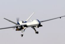 An armed MQ-9 Reaper unmanned aircraft approaching a runway