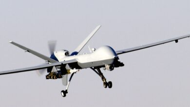 An armed MQ-9 Reaper unmanned aircraft approaching a runway