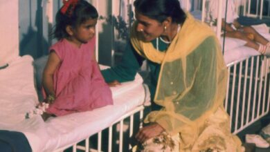 A mother sitting beside a child in a ward at AIIMS New Delhi