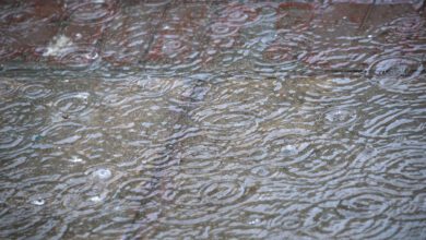 Heavy monsoon rain splashing onto a waterlogged surface in Delhi