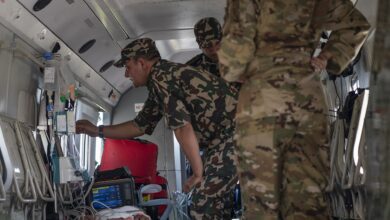 Nepali Army personnel prepare a patient for medical evacuation aboard an aircraft