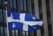 The blue and white flag of Quebec flying outside a building in Montreal