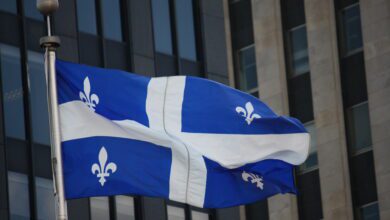 The blue and white flag of Quebec flying outside a building in Montreal