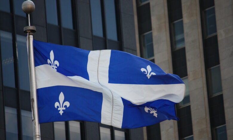 The blue and white flag of Quebec flying outside a building in Montreal
