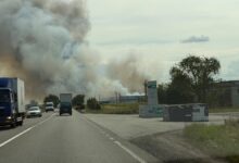 Smoke rises from a warehouse area beside a road in Ukraine after an air attack