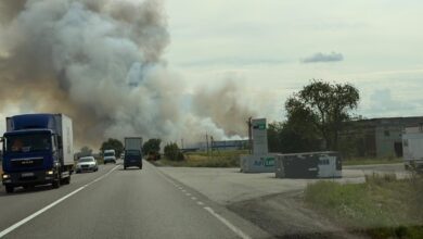 Smoke rises from a warehouse area beside a road in Ukraine after an air attack